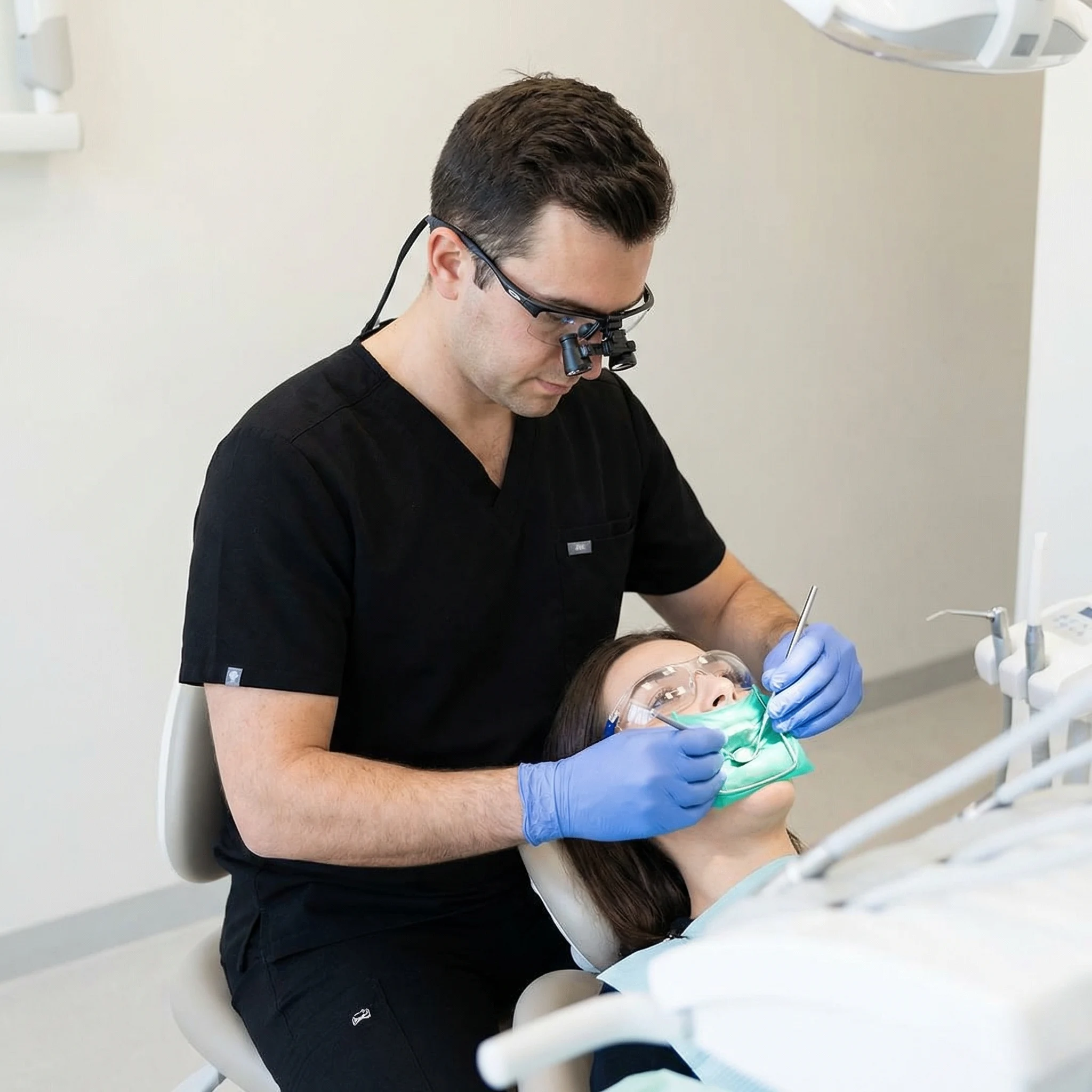 Dentist in black scrubs with latex gloves performing gentle root canal treatment on relaxed patient Dalton GA